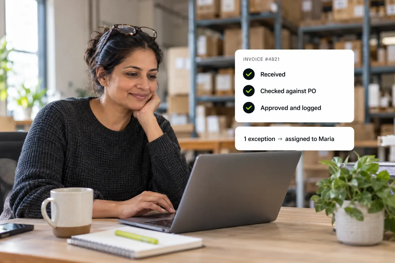 An operations manager smiles at her laptop in a warehouse office while an invoice moves from received to checked against the purchase order to approved and logged, with one exception assigned to a colleague.